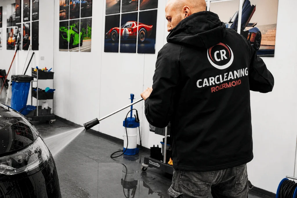 Detailer werkt aan de lak van een auto in de werkplaats